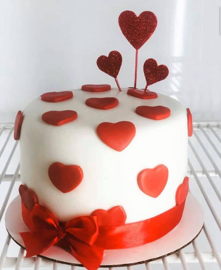 White heart cake with red hearts, hand-decorated by Bianca Mendoza